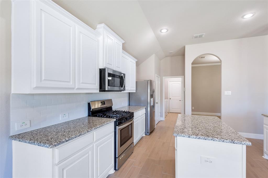 312 Eagle Ridge Road Forney, TX 75126 - Photo 12 of 39 a kitchen with stainless steel appliances granite countertop a sink stove and refrigerator