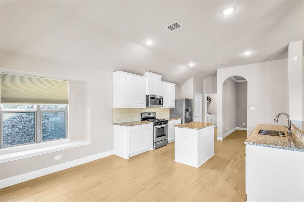 312 Eagle Ridge Road Forney, TX 75126 - Photo 17 of 39 a kitchen with a sink and a stove top oven