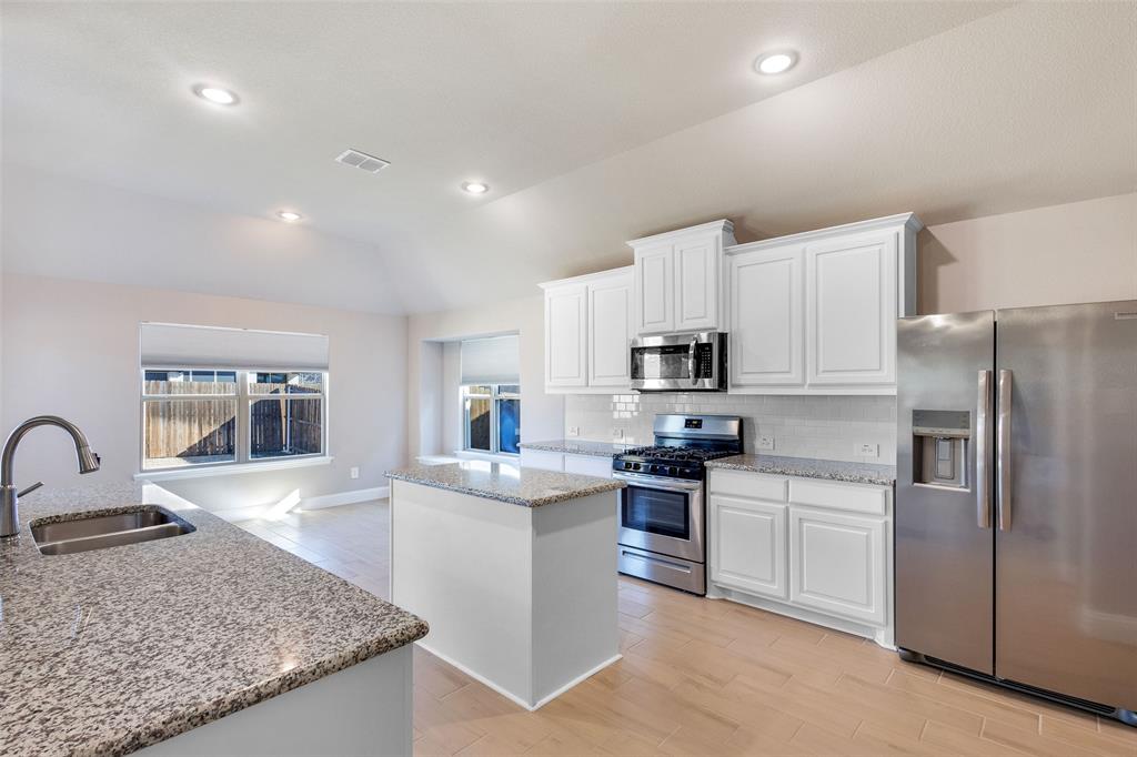 312 Eagle Ridge Road Forney, TX 75126 - Photo 18 of 39 a kitchen with stainless steel appliances granite countertop a sink stove and refrigerator