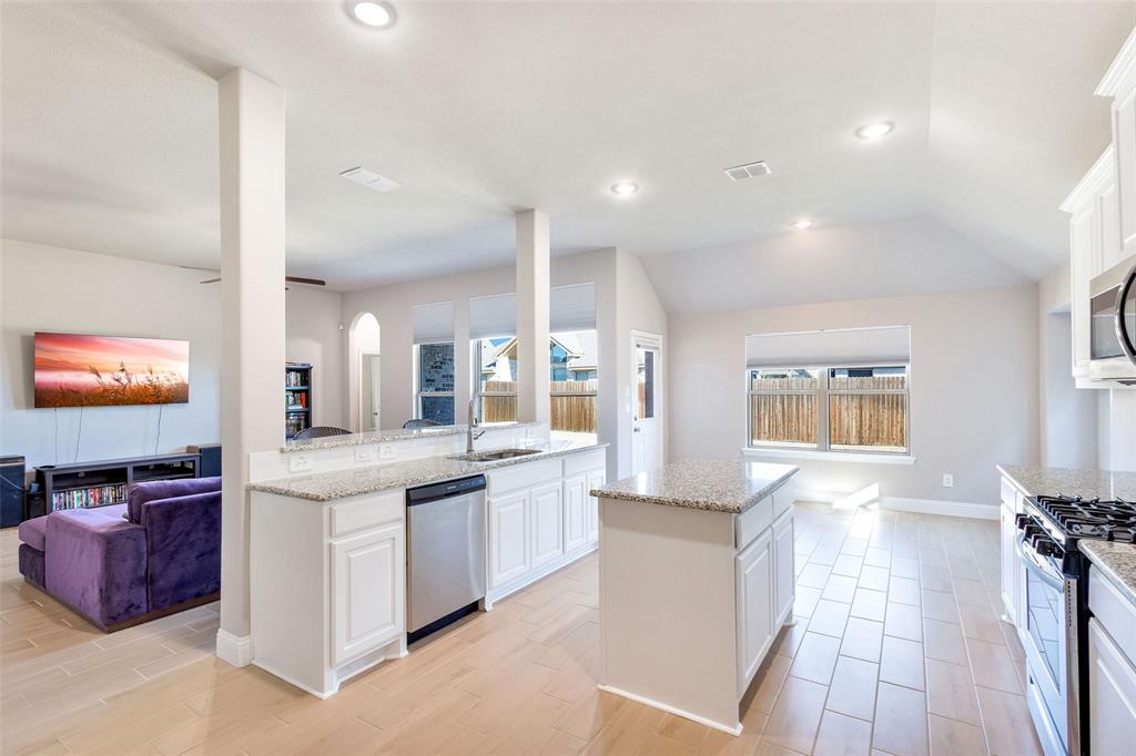 312 Eagle Ridge Road Forney, TX 75126 - Photo 19 of 39 a large kitchen with kitchen island a sink stainless steel appliances and cabinets