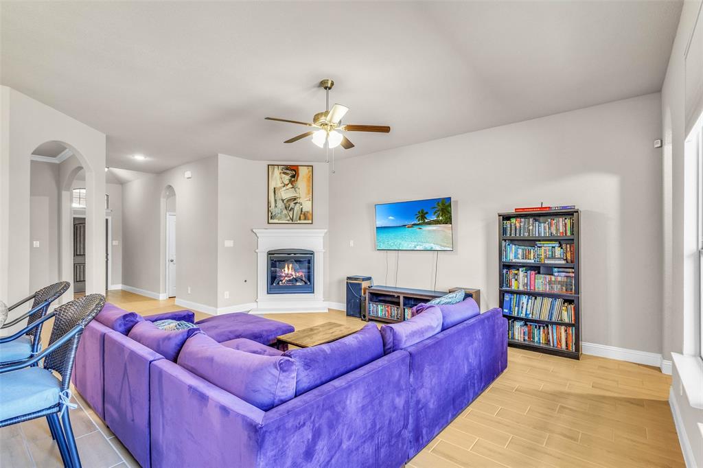 312 Eagle Ridge Road Forney, TX 75126 - Photo 7 of 39 a living room with furniture a ceiling fan and a book shelf