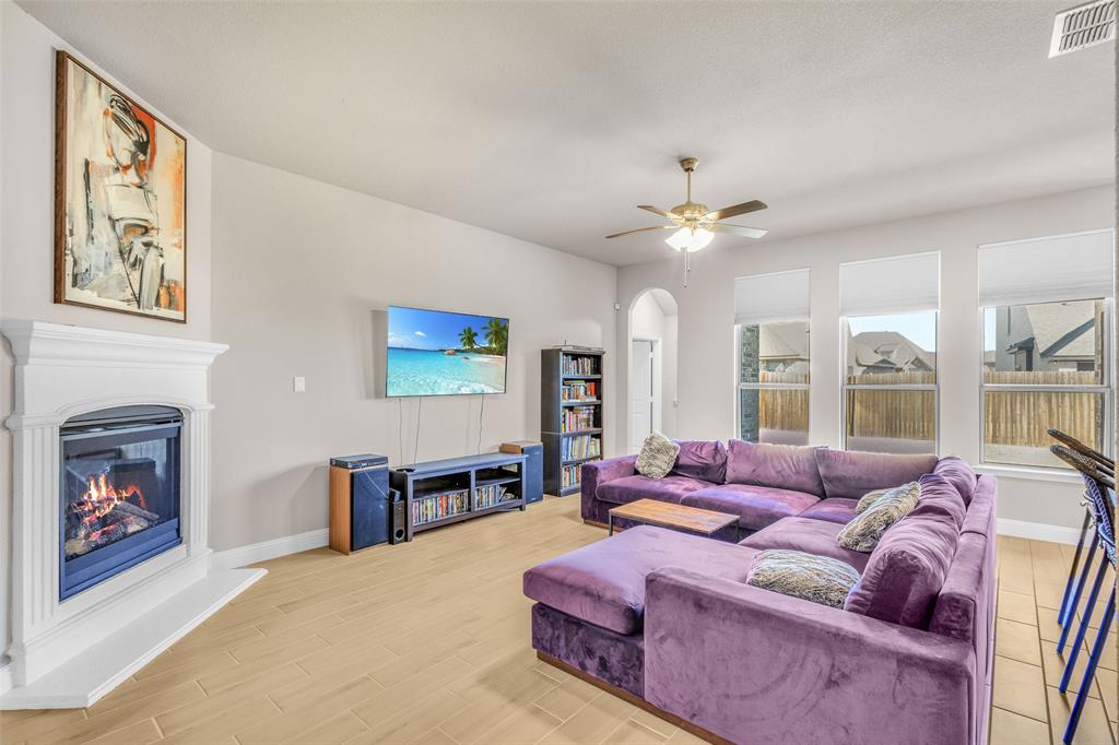 312 Eagle Ridge Road Forney, TX 75126 - Photo 9 of 39 a living room with furniture a fireplace and a large window