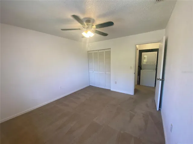 a view of an empty room and chandelier fan