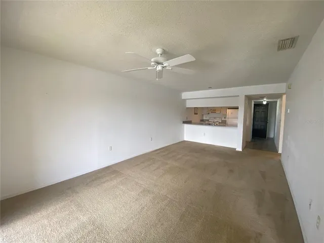 an empty room with an empty space and a ceiling fan
