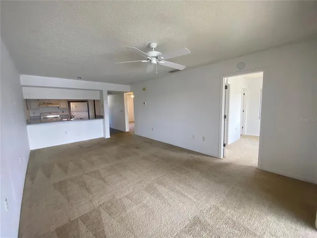 a view of a big room with chandelier fan and windows