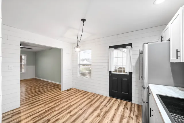 a kitchen with stainless steel appliances granite countertop a refrigerator a stove and a sink with wooden floor