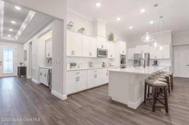 a kitchen with a sink cabinets stainless steel appliances and wooden floor