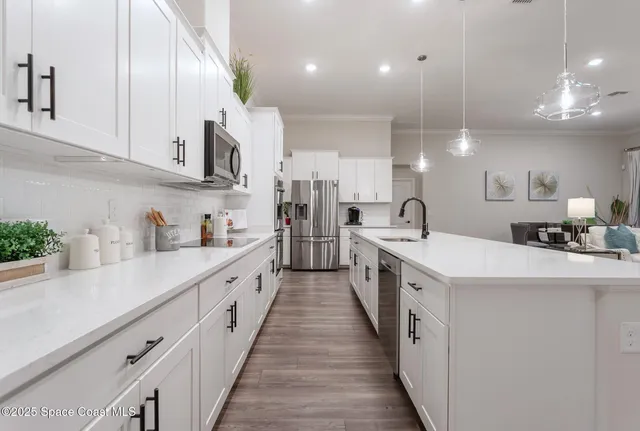 a large white kitchen with lots of counter space and a sink