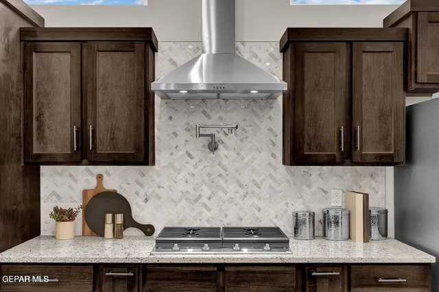 a kitchen with a stove a counter space dining table and chairs