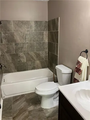 a bathroom with a toilet and a bath tub