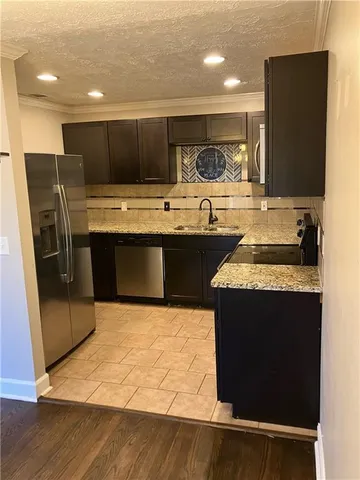 a kitchen with stainless steel appliances granite countertop a sink and a stove