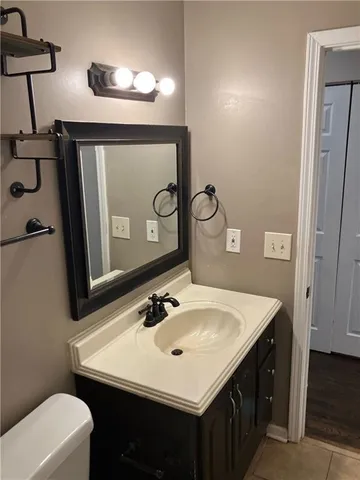 a bathroom with a sink vanity and a toilet