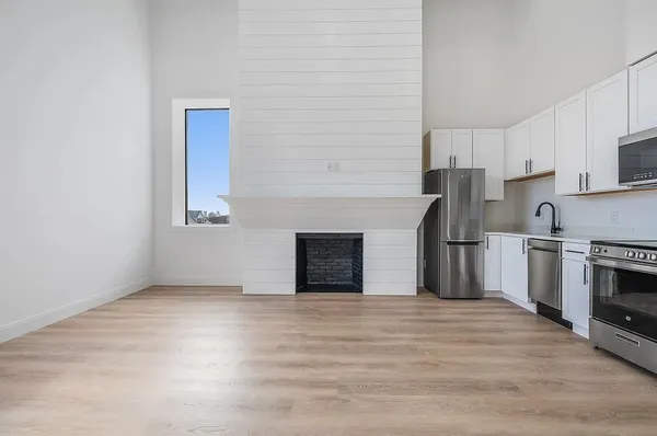 a view of kitchen with granite countertop stainless steel appliances and sink