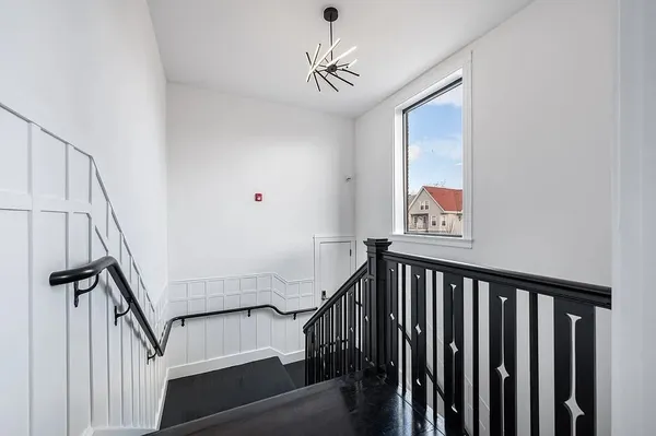 a view of a hallway with wooden floor and staircase