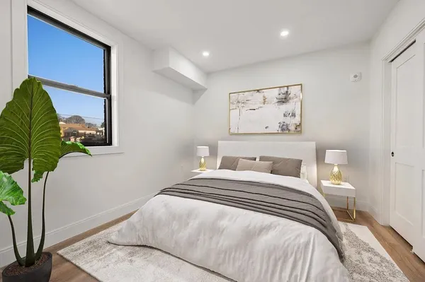 a bedroom with a bed and a potted plant