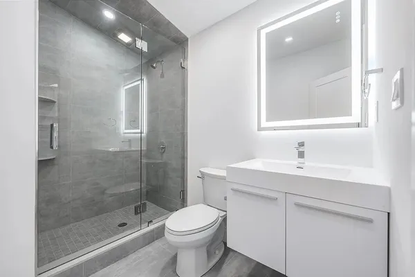 a bathroom with a sink a toilet and shower