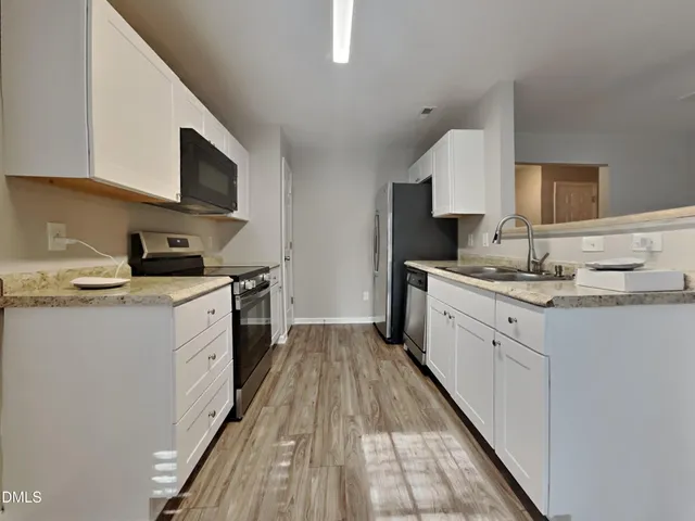 a kitchen with granite countertop a sink and a stove top oven