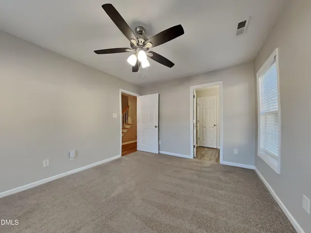 a view of an empty room with a ceiling fan