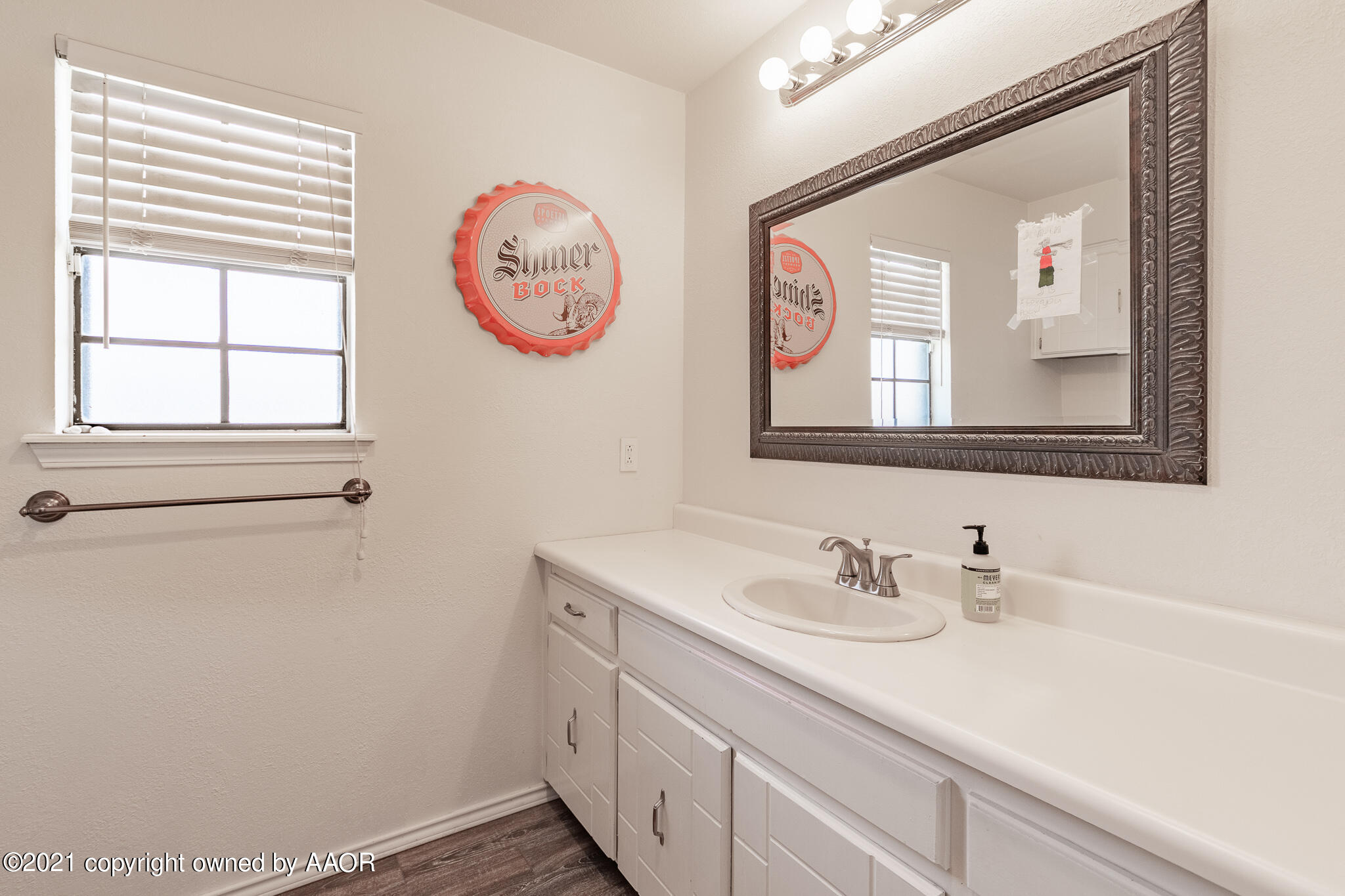 7306 Imperial Drive Amarillo, TX 79121 - Photo 18 of 24 a bathroom with a sink a mirror and a window