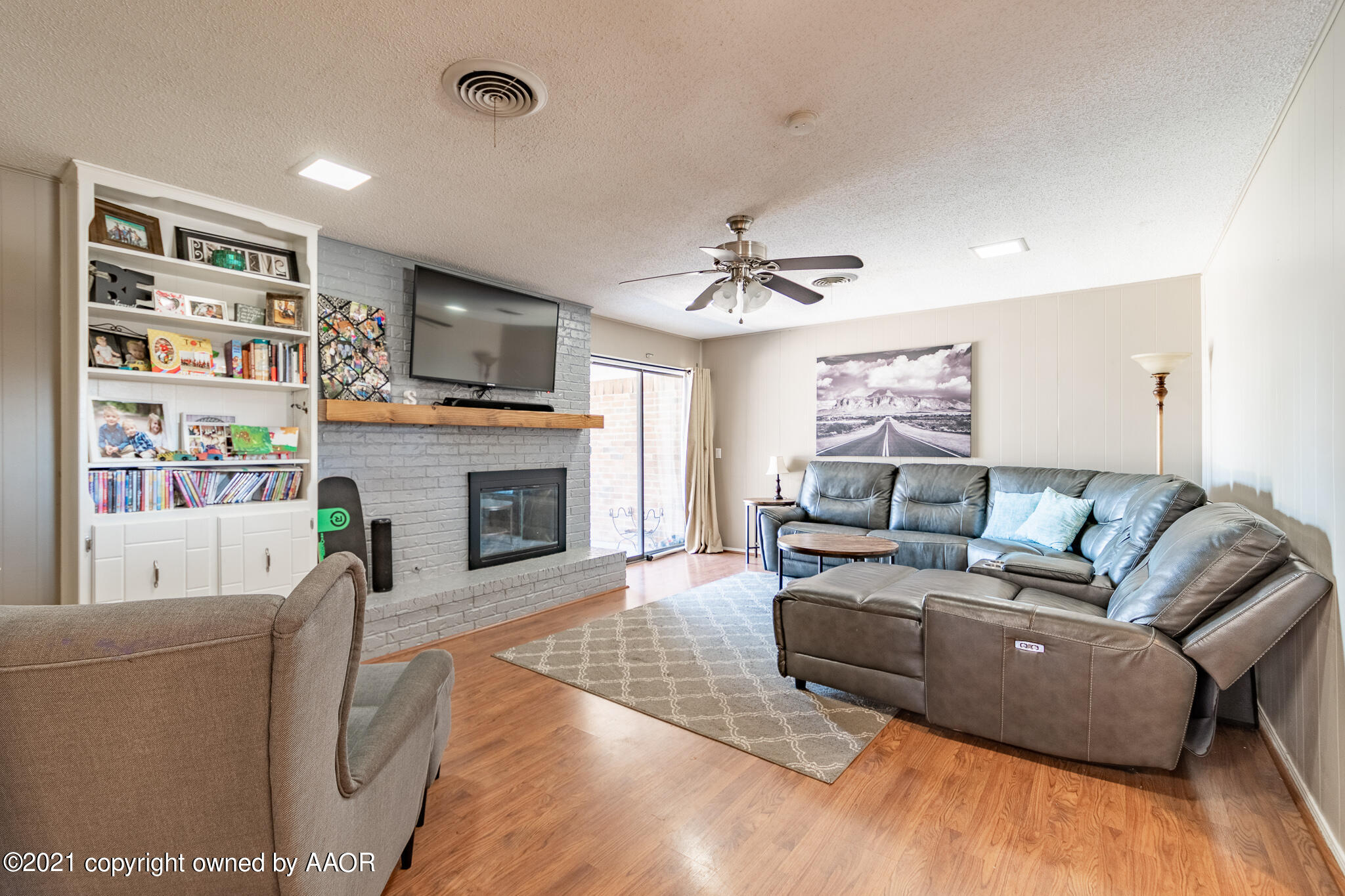 7306 Imperial Drive Amarillo, TX 79121 - Photo 9 of 24 a living room with furniture a fireplace and a flat screen tv