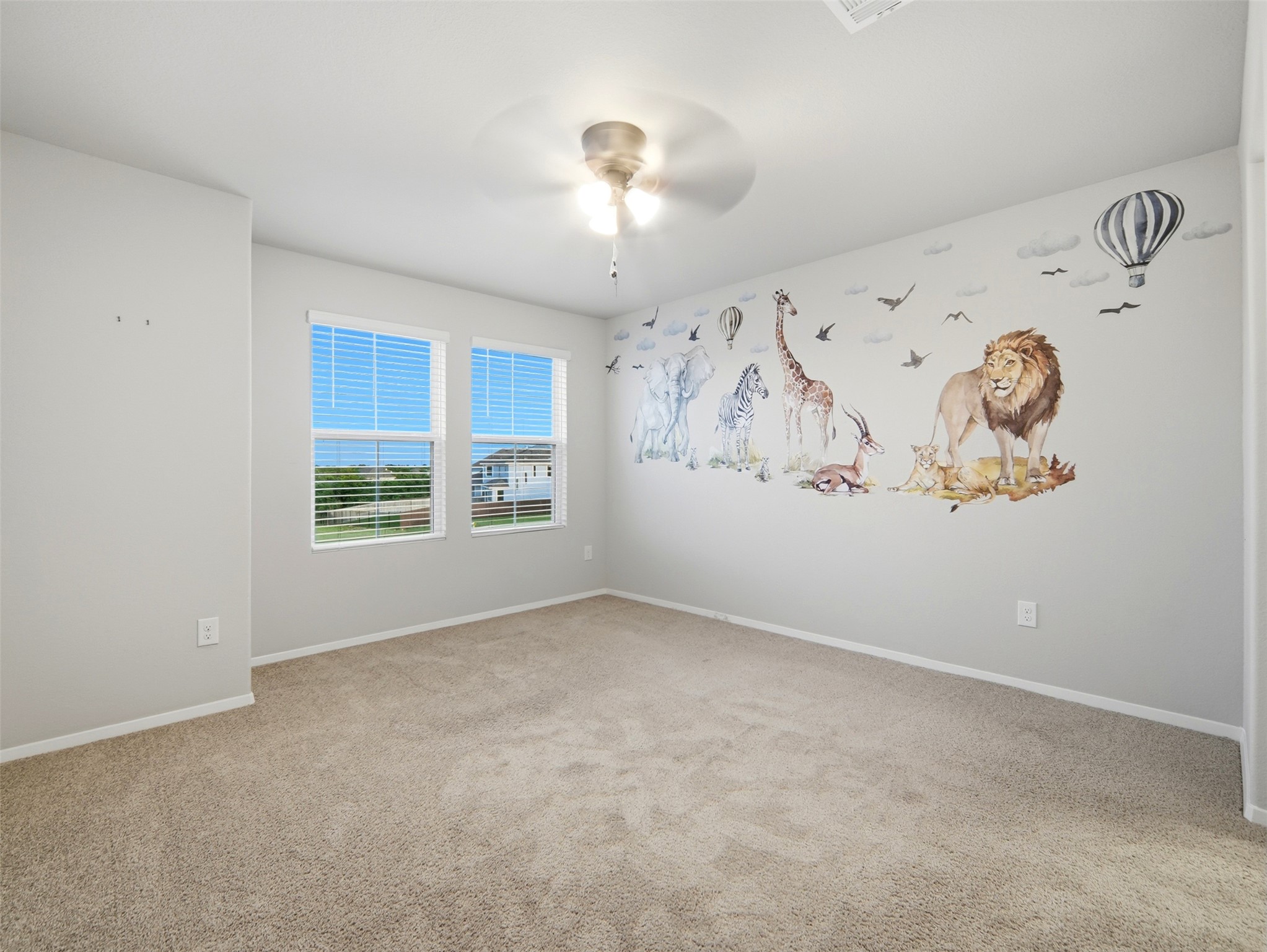 60 Bent Trl Lane Georgetown, TX 78628 - Photo 16 of 40 A well-lit bedroom features plush carpeting and playful wall art, creating an inviting personal space.