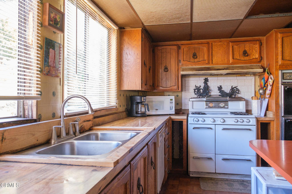 8624 Nye Road Ventura, CA 93001 - Photo 27 of 39 a kitchen with stainless steel appliances granite countertop a sink and cabinets