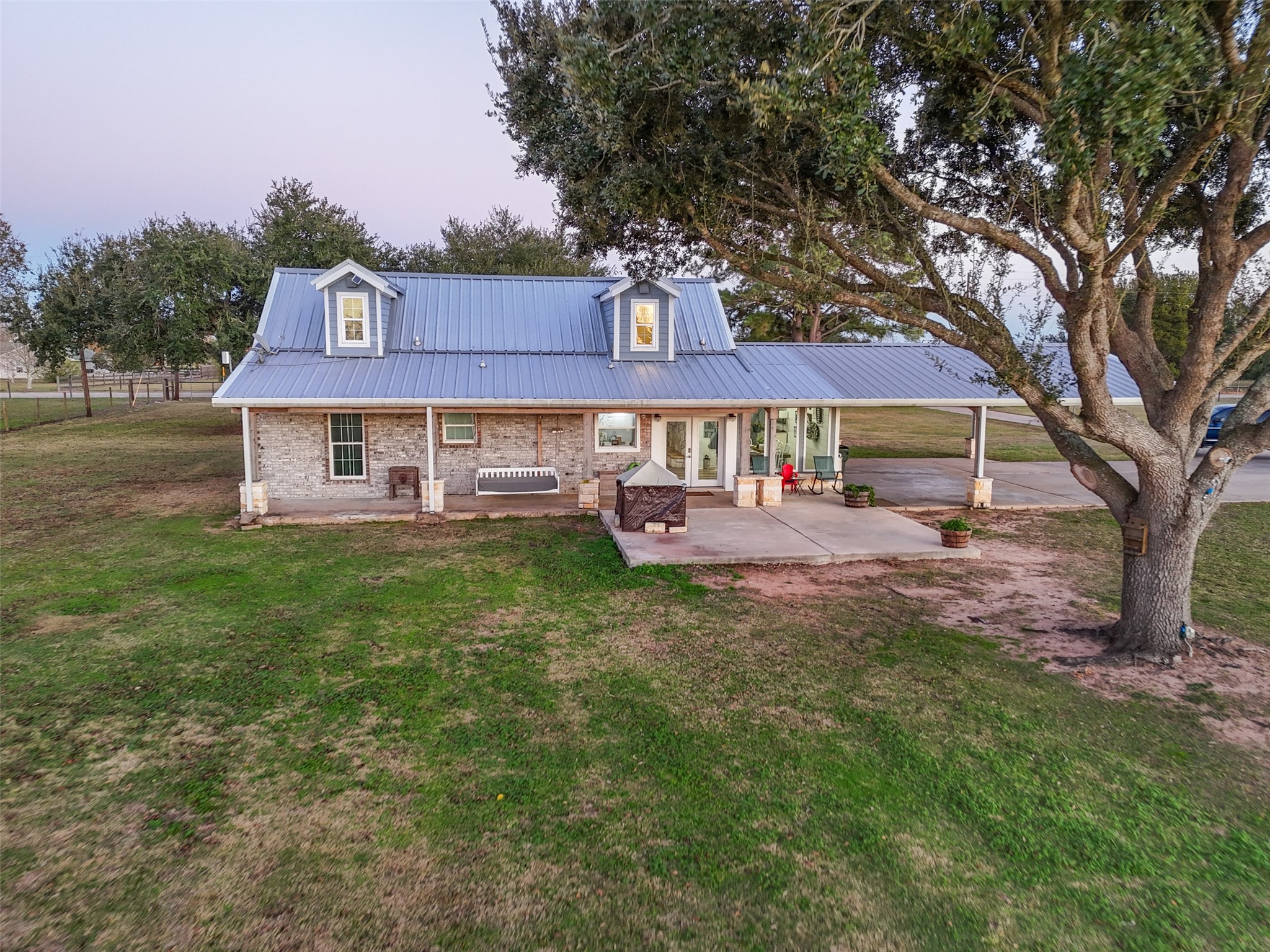 19989 Meadow Bend Road Hempstead, TX 77445 - Photo 31 of 35 Rear exterior features expansive covered porch areas ideal for outdoor living, with views across the surrounding pasture.