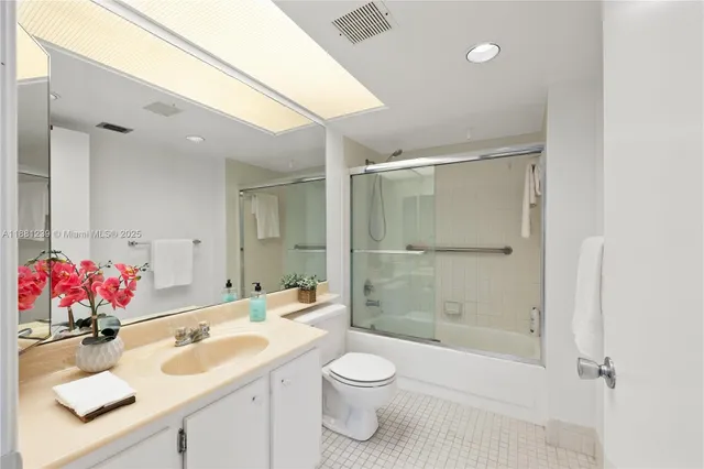 a bathroom with a sink vanity mirror and toilet