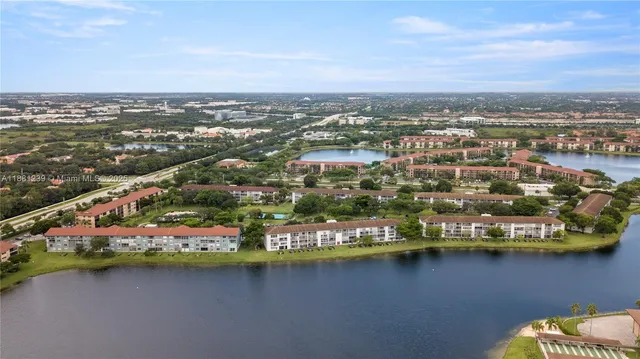 an aerial view of residential houses with outdoor space and lake view