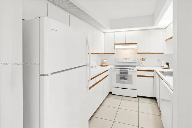 a kitchen with white cabinets and white appliances