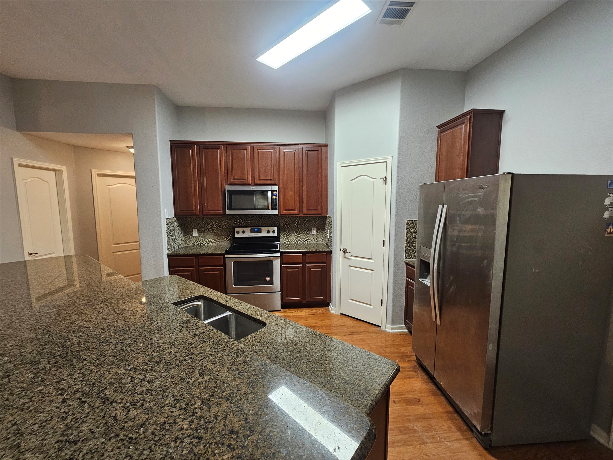 2035 Intrepid Drive Buda, TX 78610 - Photo 8 of 26 A well-appointed kitchen showcasing durable granite counters and rich wooden cabinetry.