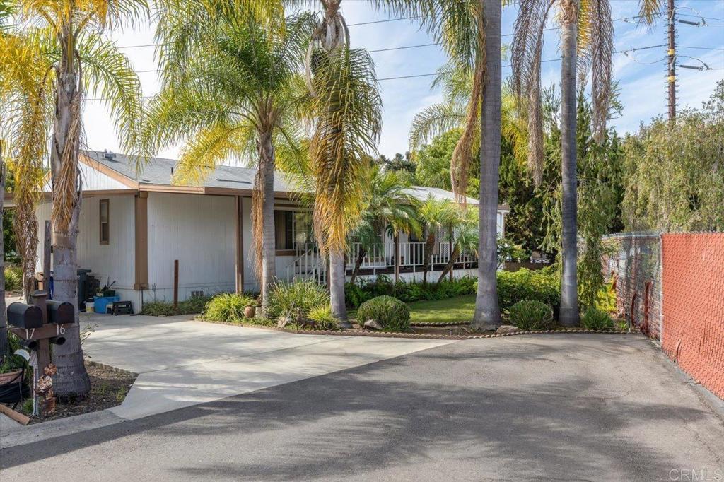 a front view of a house with a yard and palm trees