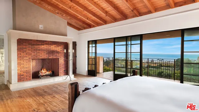 a bedroom with a bed and large windows