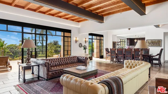 a living room with furniture and floor to ceiling windows