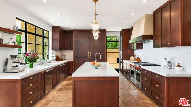 a kitchen with kitchen island granite countertop a sink counter top space appliances and cabinets