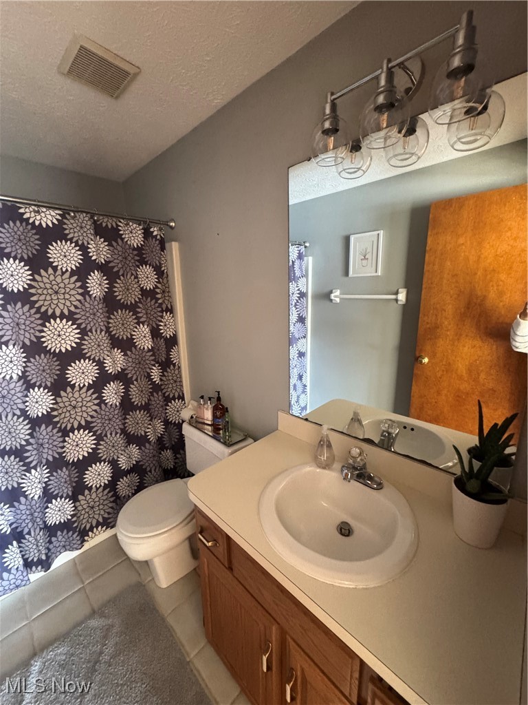 3530 State Road Medina, OH 44256 - Photo 32 of 47 Full bath with visible vents, toilet, tile patterned floors, a textured ceiling, and vanity