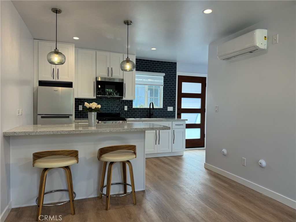 827 Delaware Road, Unit ADU Burbank, CA 91504 - Photo 3 of 20 a kitchen with stainless steel appliances granite countertop a stove top oven a sink dishwasher a dining table and chairs with wooden floor