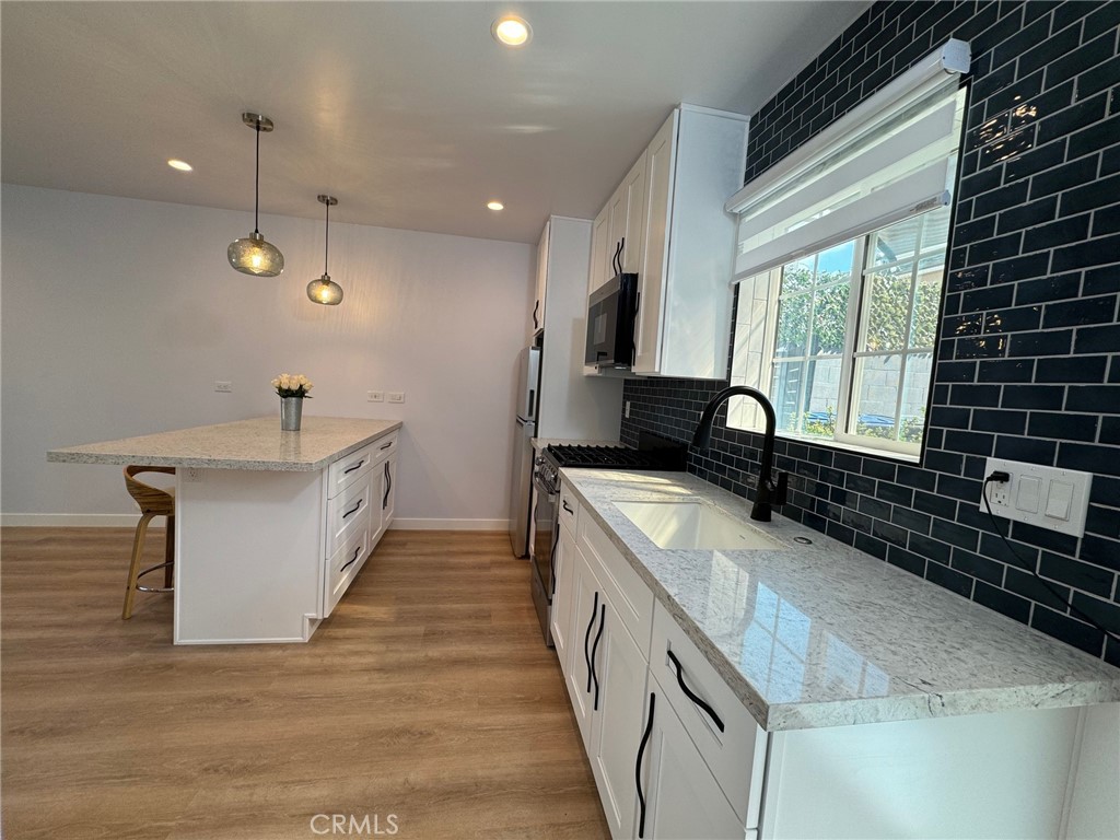 827 Delaware Road, Unit ADU Burbank, CA 91504 - Photo 8 of 20 a kitchen with kitchen island granite countertop a sink and a stove top oven