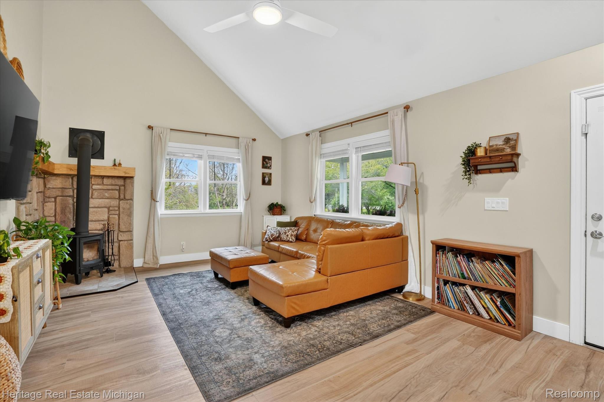 5835 Warner Road Fowlerville, MI 48836 - Photo 6 of 59 Living room featuring a wood stove, light wood-type flooring, a ceiling fan, and vaulted ceiling