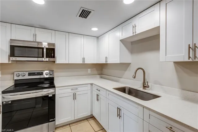 a kitchen with appliances a sink and cabinets