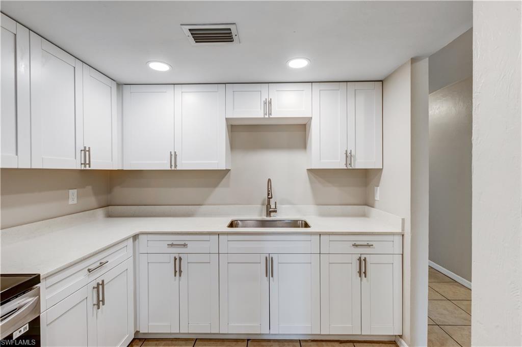 5453 16th Place Southwest Naples, FL 34116 - Photo 6 of 36 a kitchen with a sink and cabinets