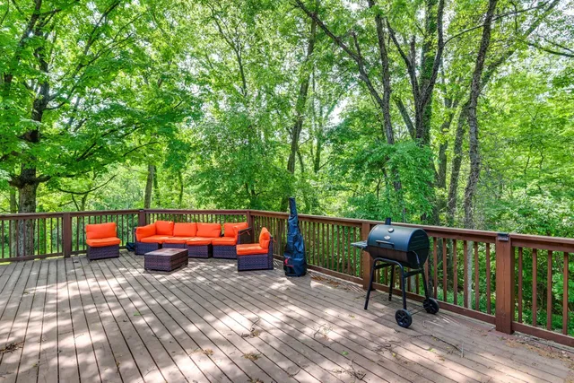 a balcony with wooden floor and trees in the back