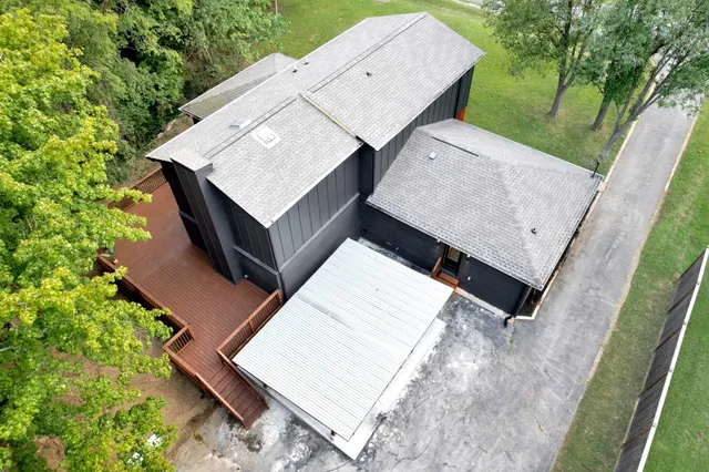 an aerial view of residential houses with outdoor space and trees