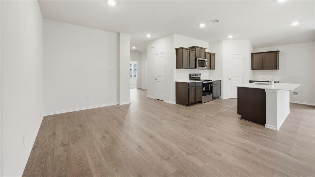 4615 Enclave Drive Sanger, TX 76266 - Photo 29 of 35 a large kitchen with stainless steel appliances a large counter top and a couch