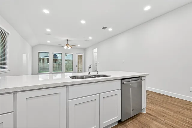 a kitchen with white cabinets and appliances