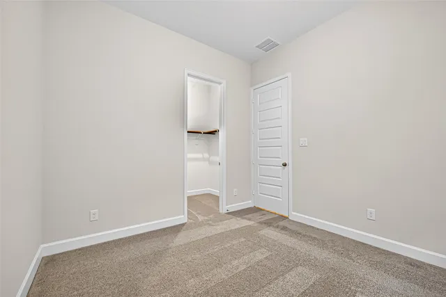 an empty room with windows and cabinet