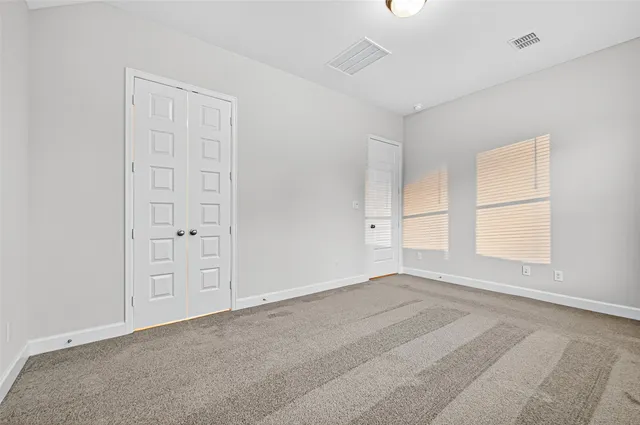 an empty room with windows and closet