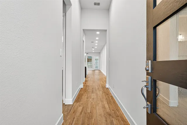 a view of a hallway with wooden floor and staircase