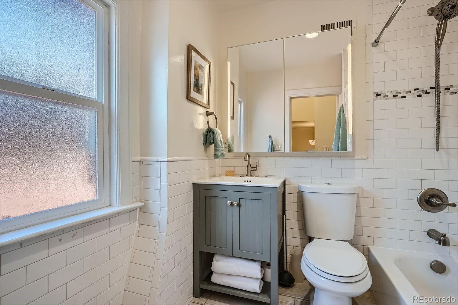 1516 Cook Street Denver, CO 80206 - Photo 19 of 35 a bathroom with a granite countertop toilet sink and mirror