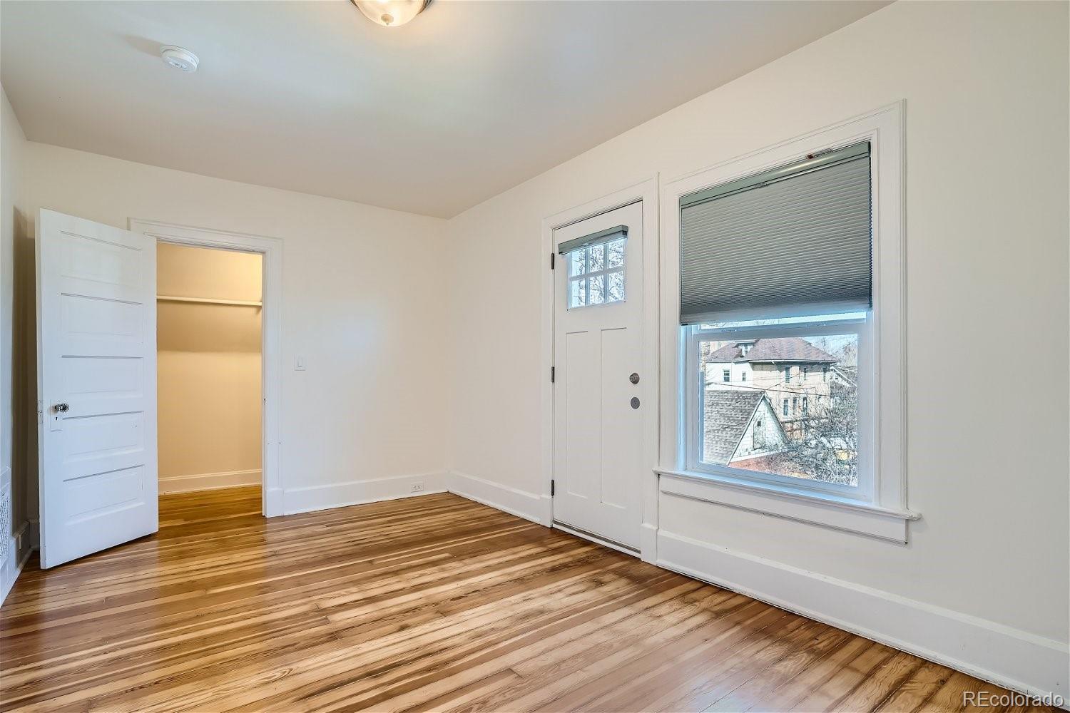 1516 Cook Street Denver, CO 80206 - Photo 20 of 35 a view of an empty room with wooden floor and a window